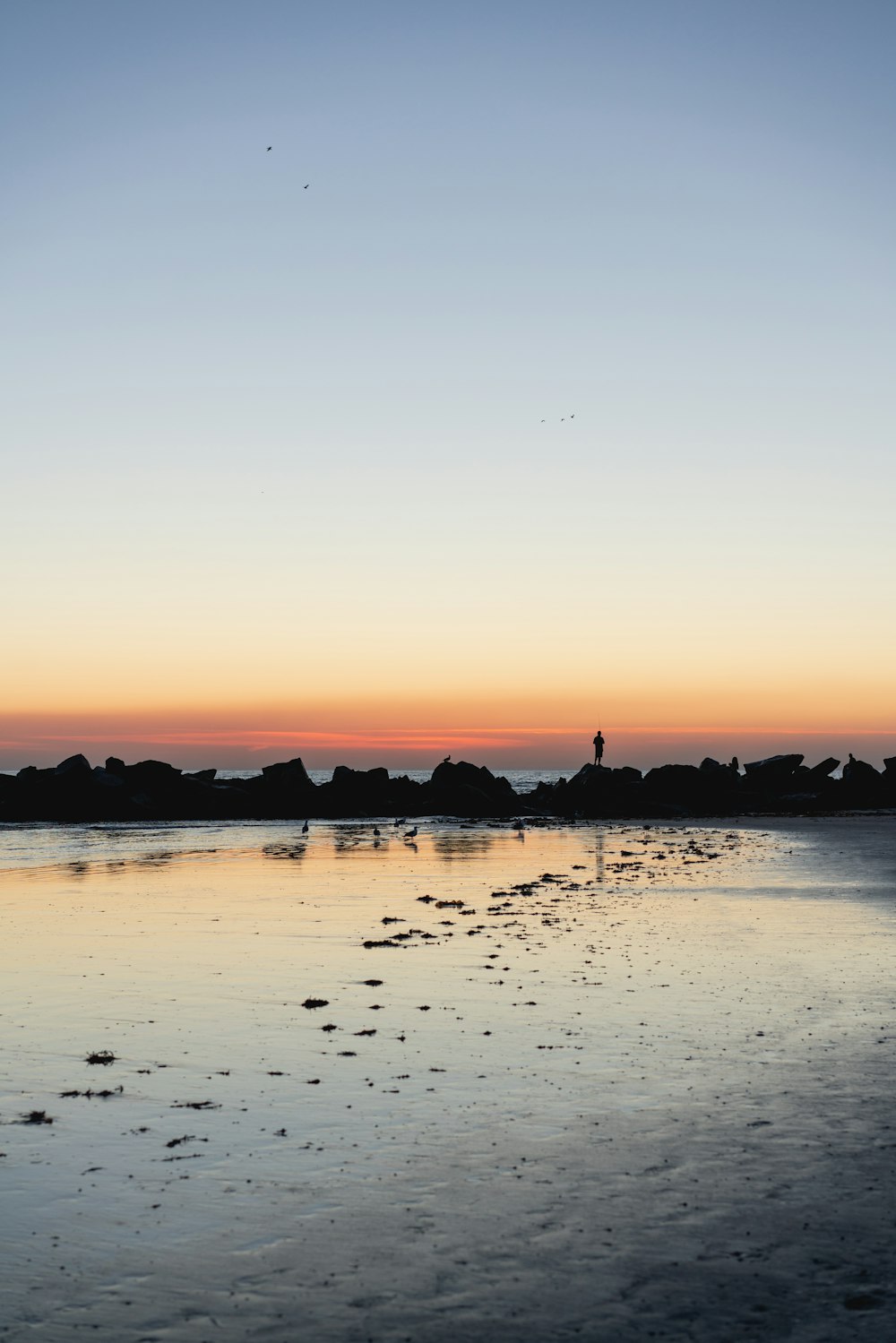 silhouette of sea under orange skies