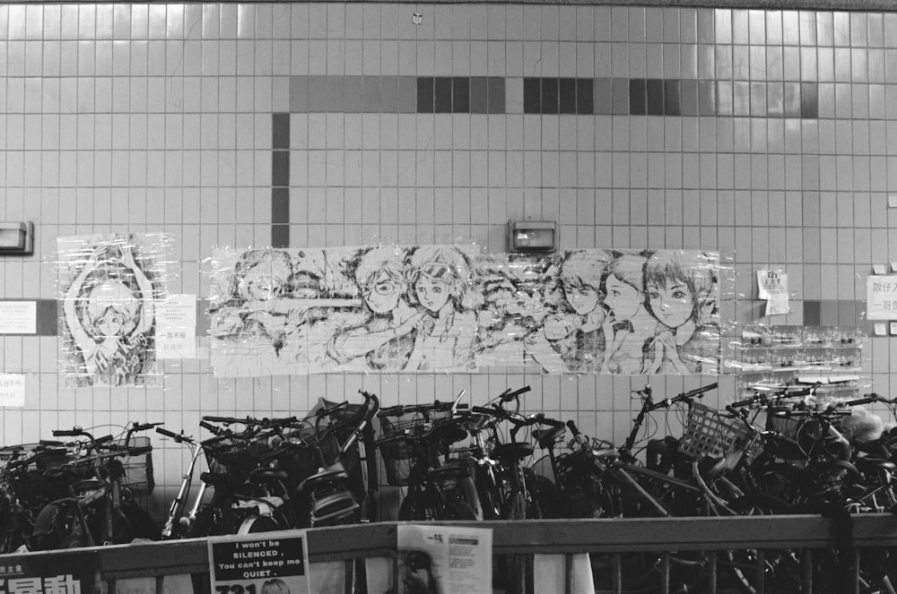 grayscale photography of bikes parking near wall