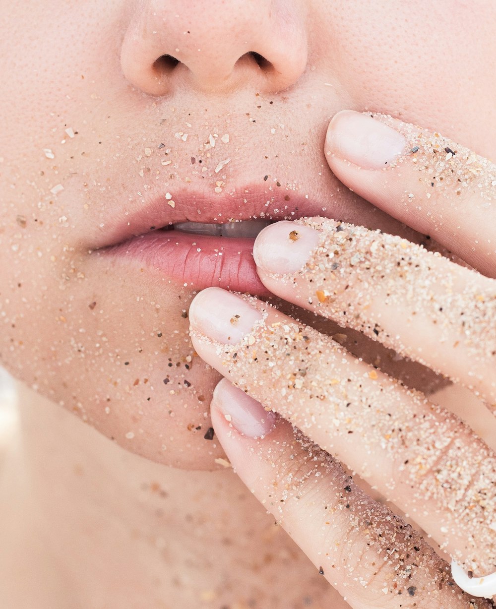 person holding lips covered in sands