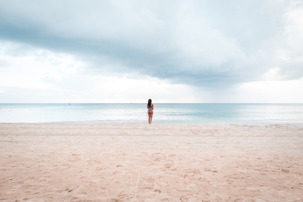 Persona in piedi in riva al mare durante il giorno