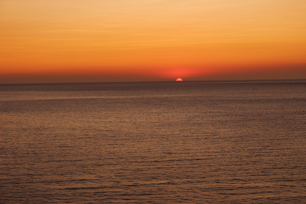 photograph of ocean during sunset