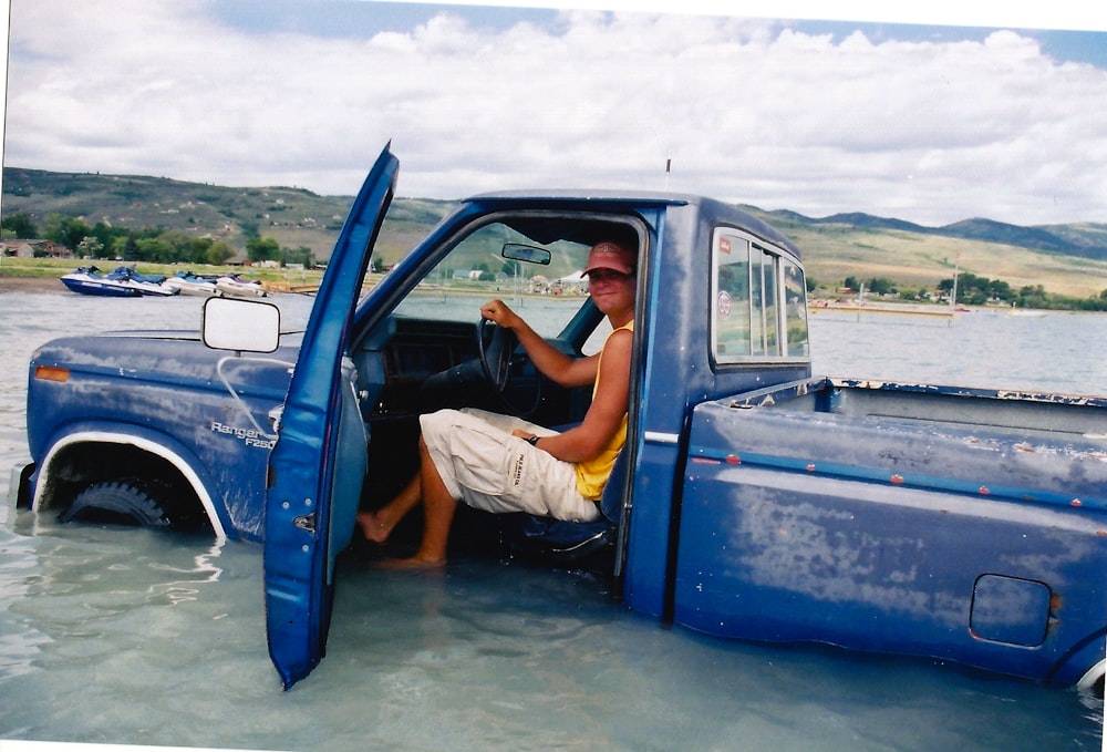 man inside blue pickup truck