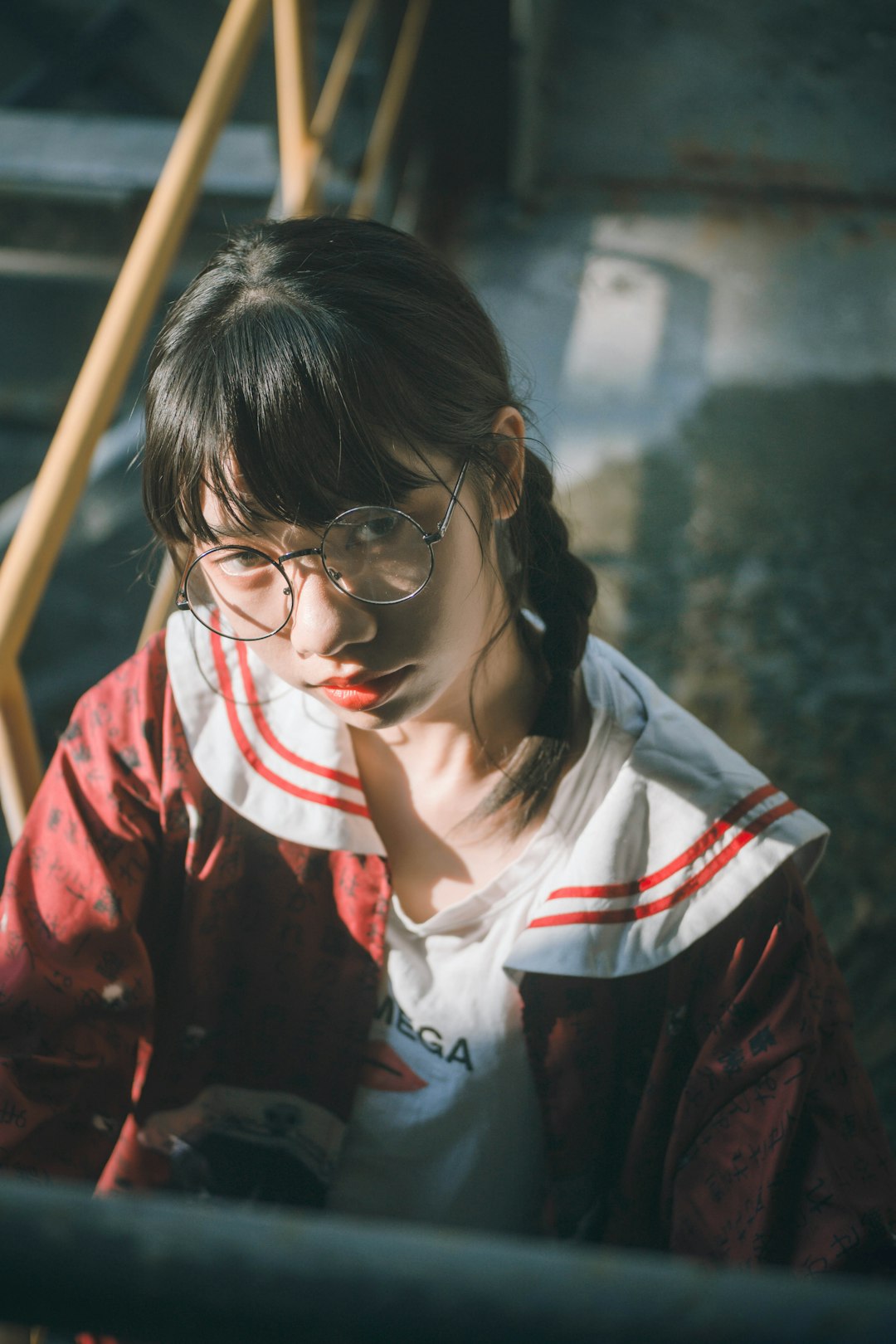 girl in red jacket beside metal rail