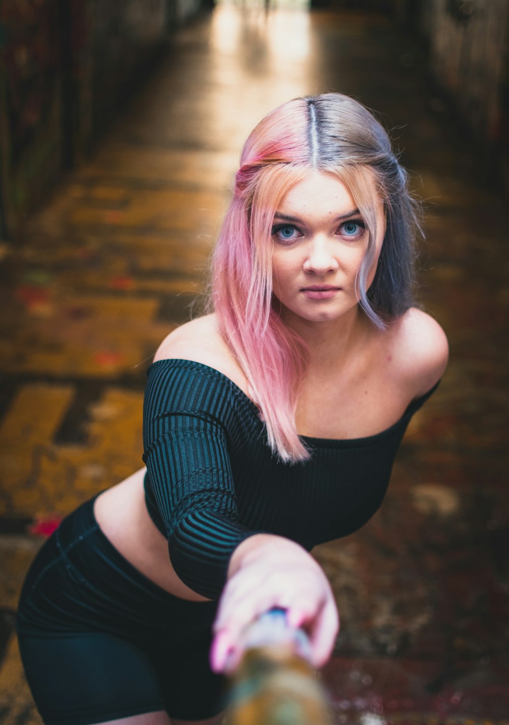 a woman with pink hair is kneeling down