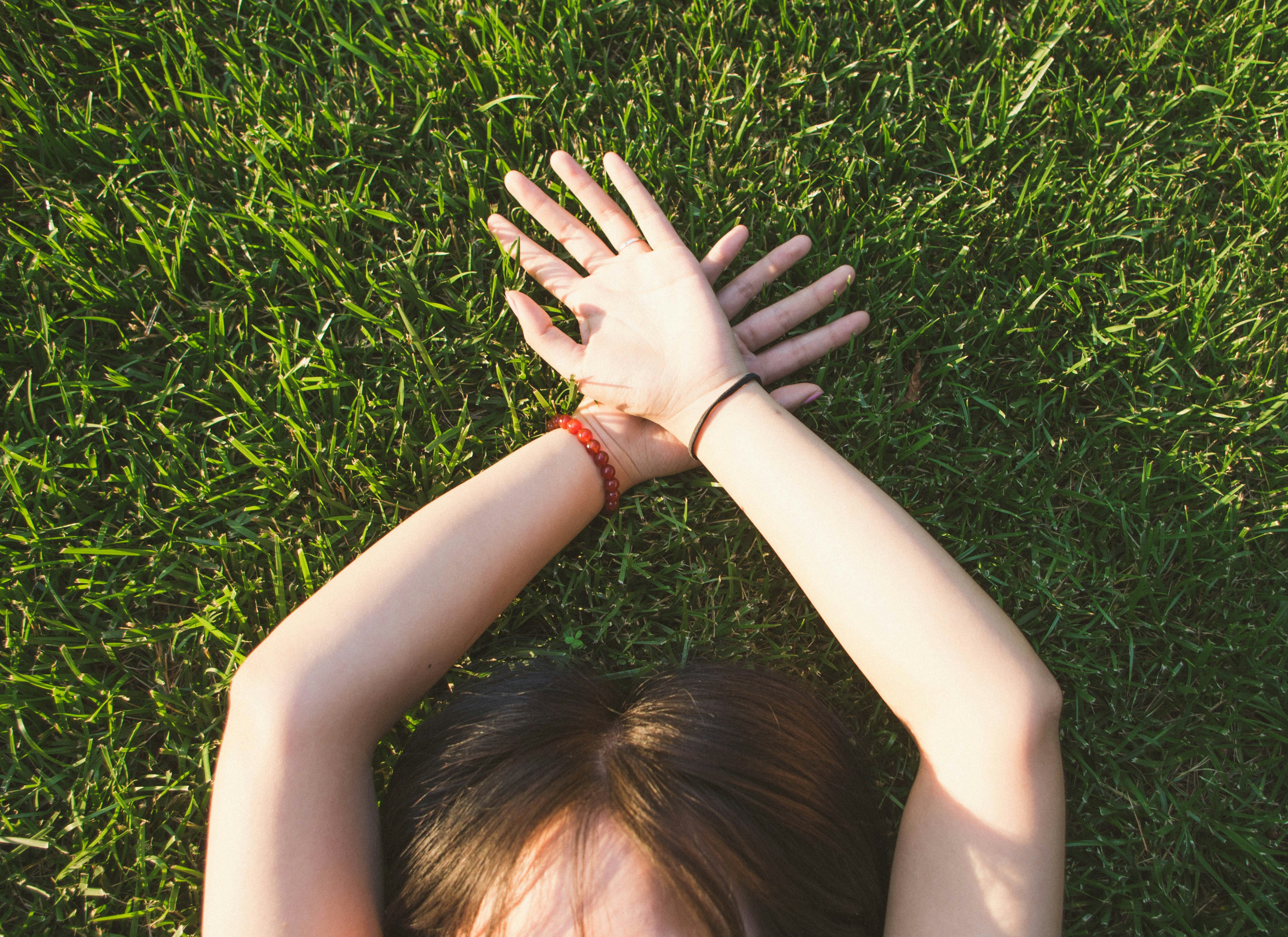 woman lying on green grass