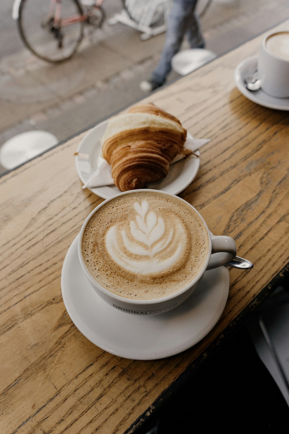 cup of cappuccino near croissant bread