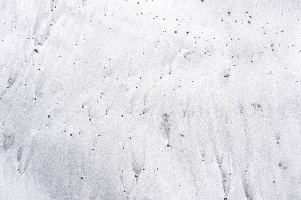 a snow covered ground with footprints in the snow