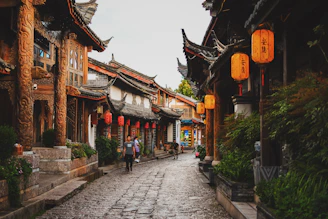 A quiet ancient town street lined with old wooden houses and red lanterns.
