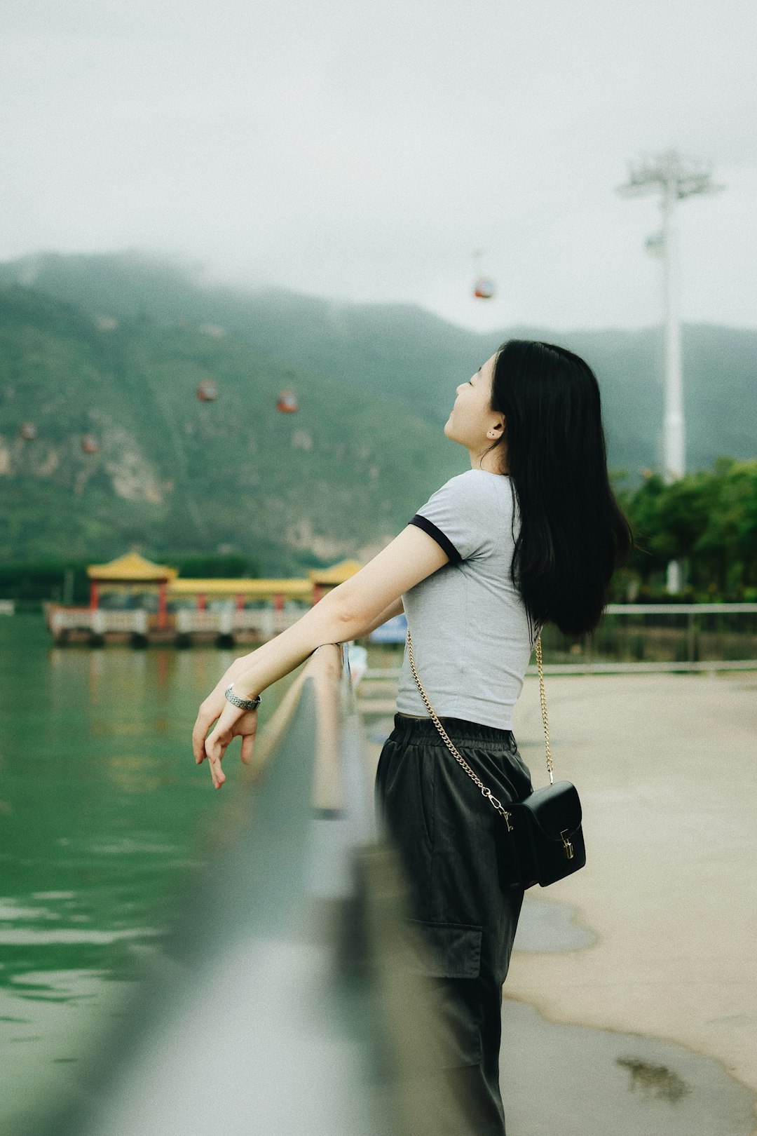 woman leaning on gray metal railing