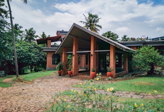 a brick house with potted plants in front of it