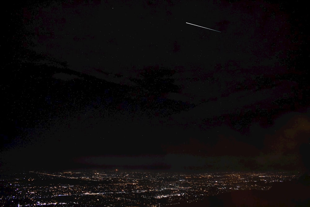 an airplane flying over a city at night