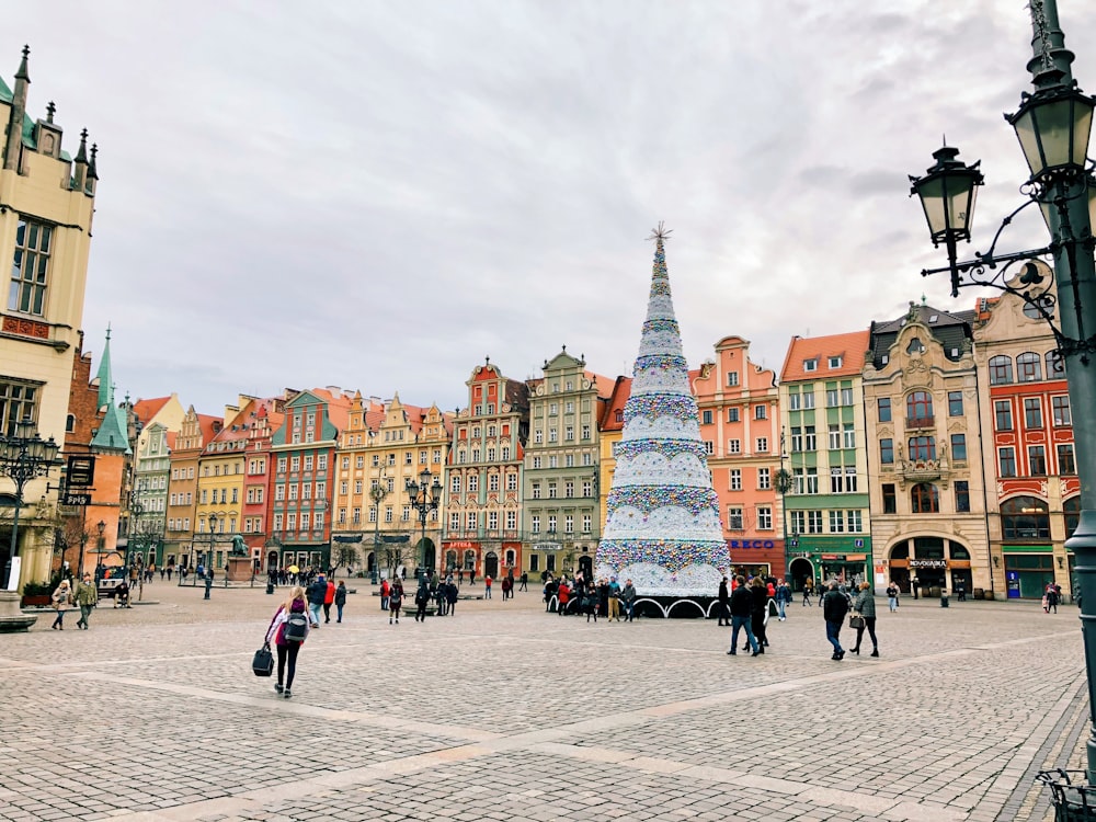 people walking beside giant Christmas tree