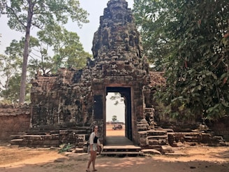 Sunlight filtering through ancient temple gates with intricate stone carvings.