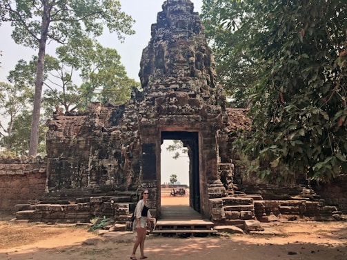 Sunlight filtering through ancient temple gates with intricate stone carvings.