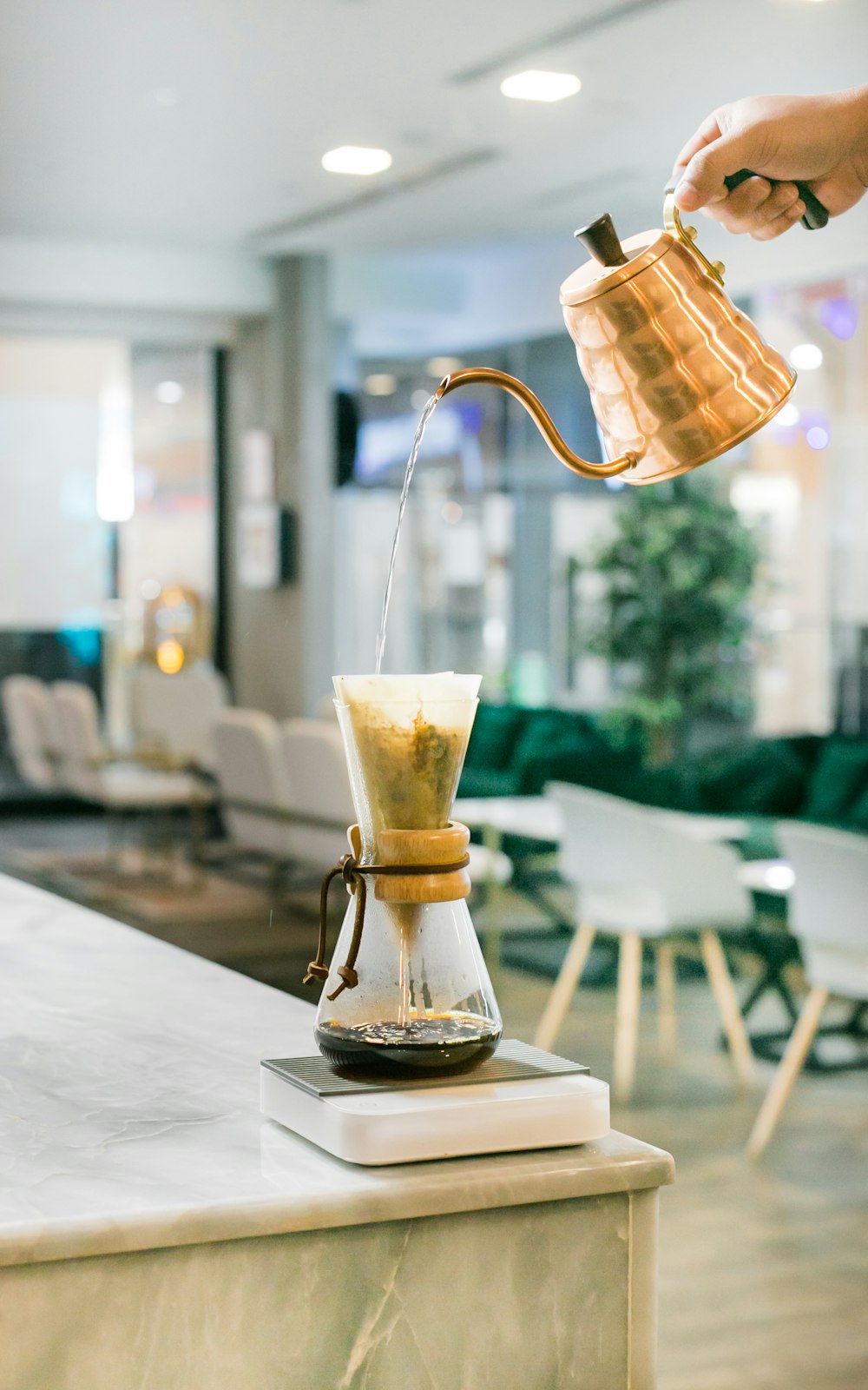 person pouring water in a coffee pot close-up photography