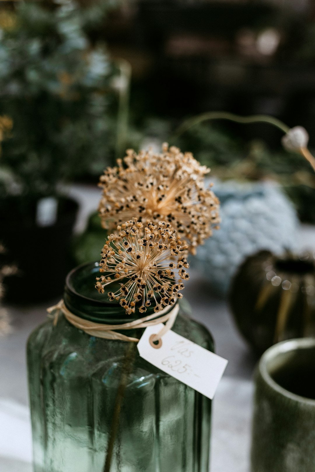 beige flowers in green glass jar