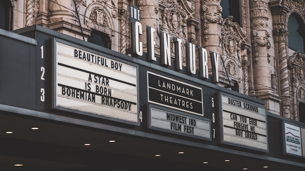 a theater marquee with a large building in the background