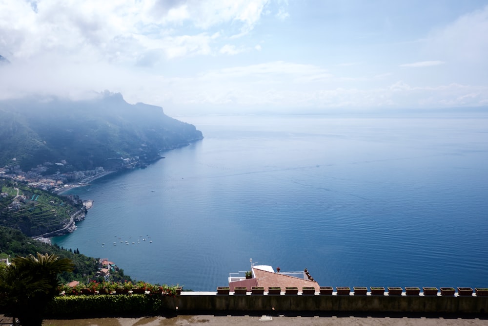 a large body of water sitting next to a lush green hillside