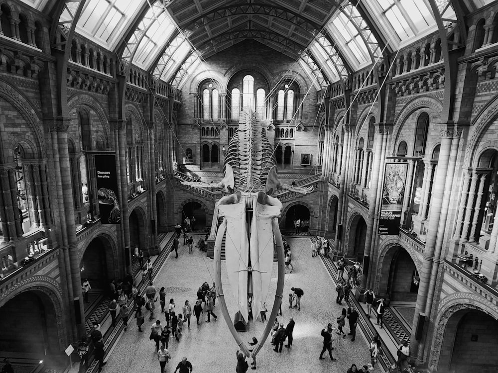 greyscale photo of people walking inside building