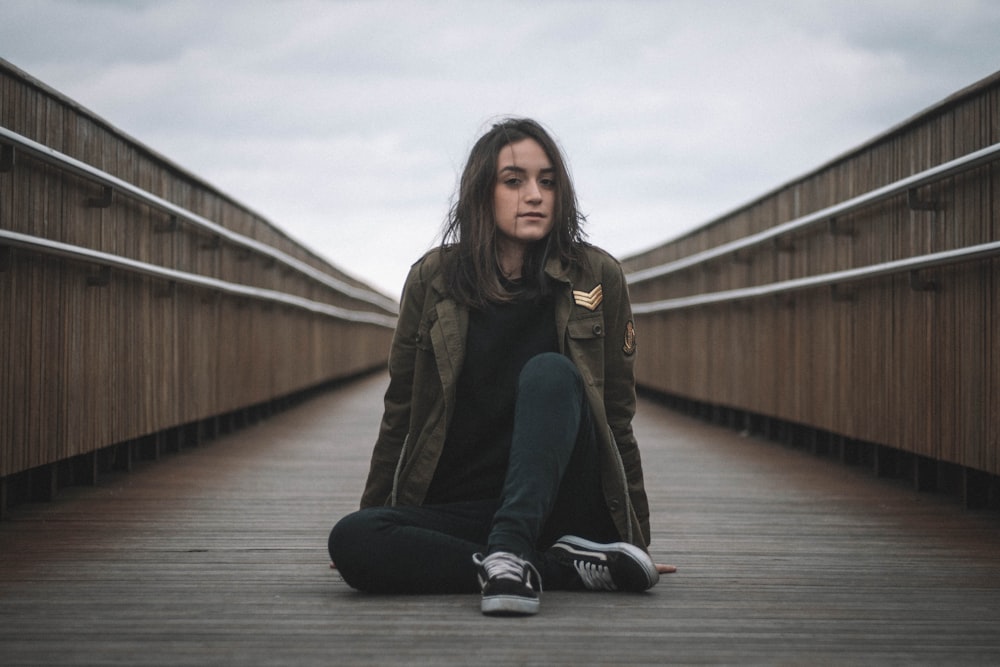 woman sitting on brown wooden floor