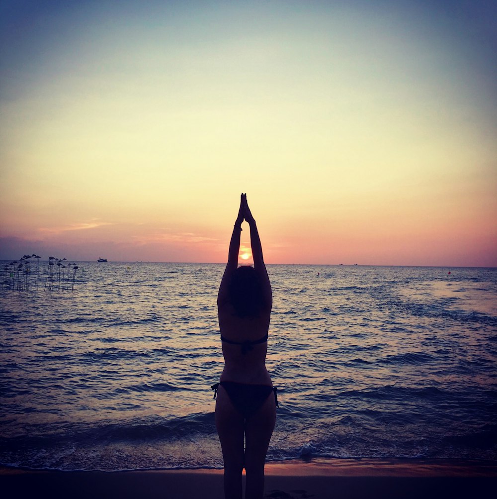 silhouette photography of woman raising her hands