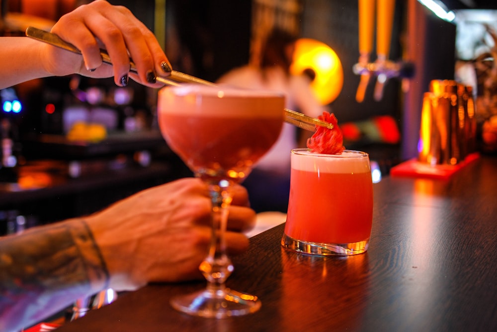 bartender putting red ingredient on cocktail drinks