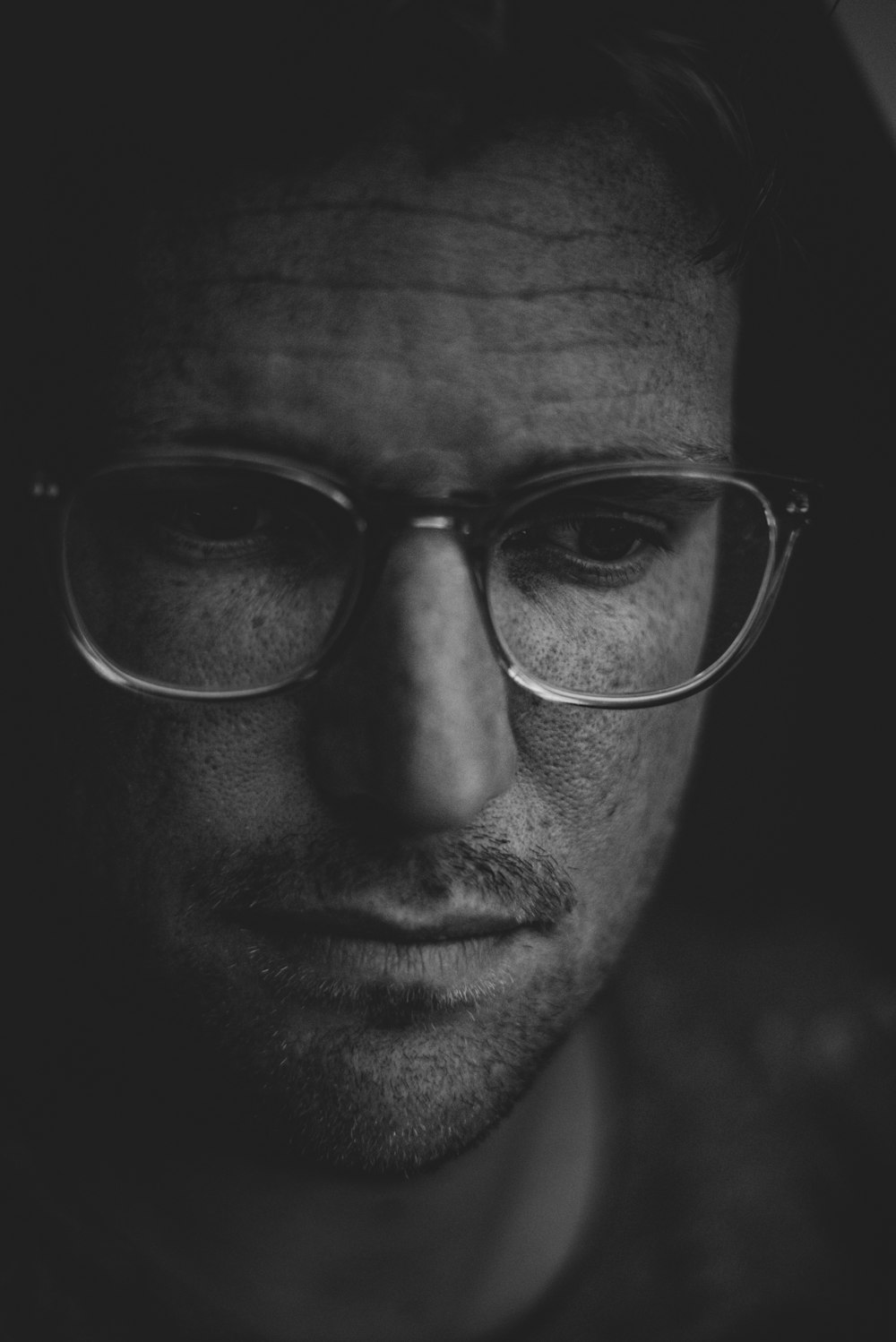 foto in scala di grigi di uomo che indossa occhiali da vista