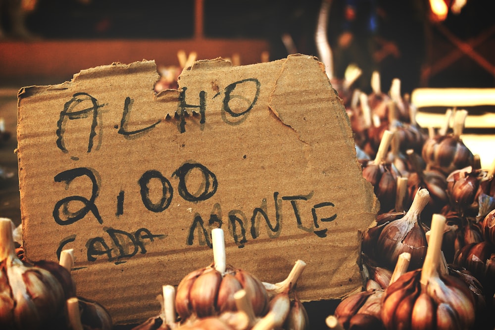 a cardboard sign that is on top of some garlic