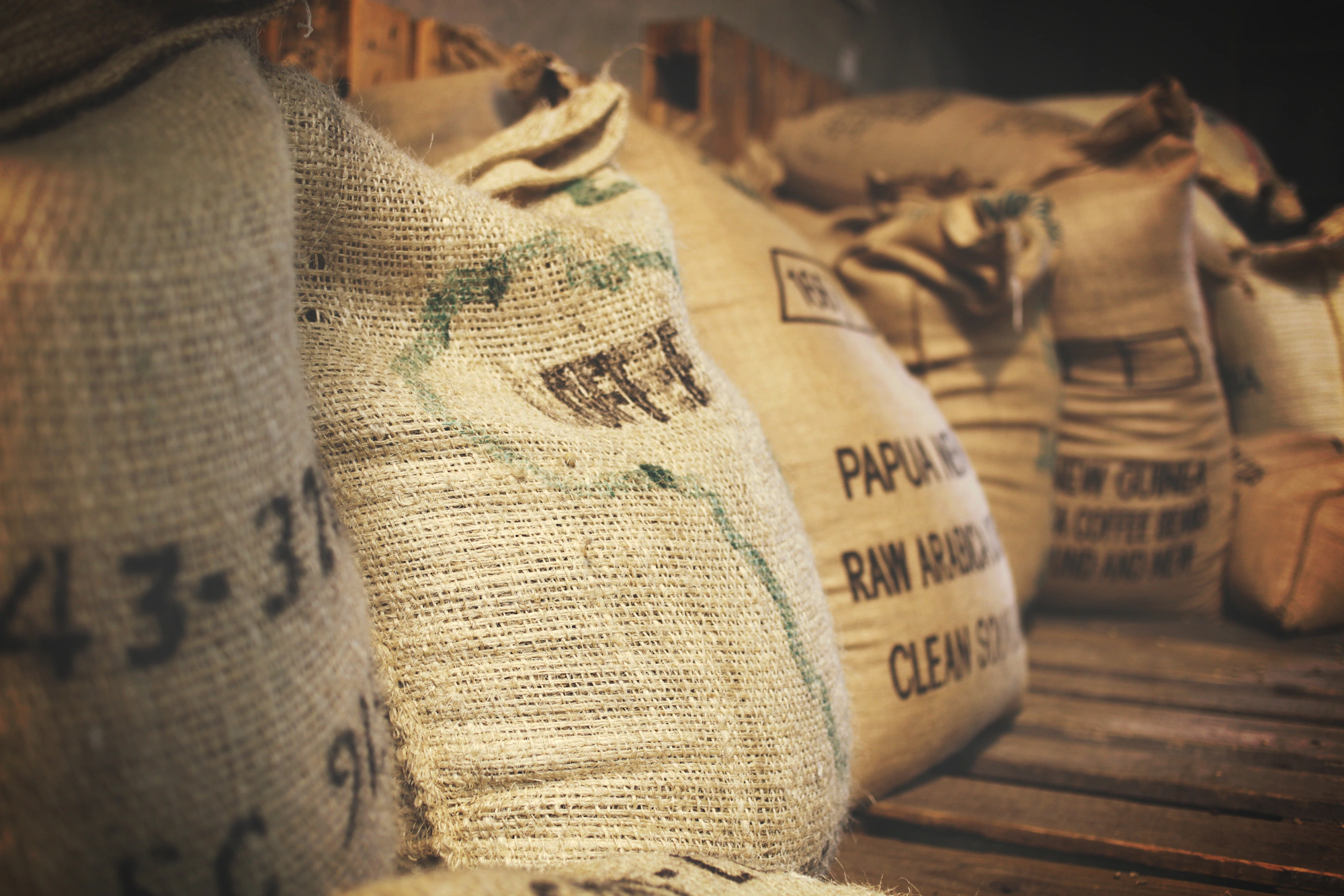 Stacked burlap sacks of bulk food ingredients in a warehouse