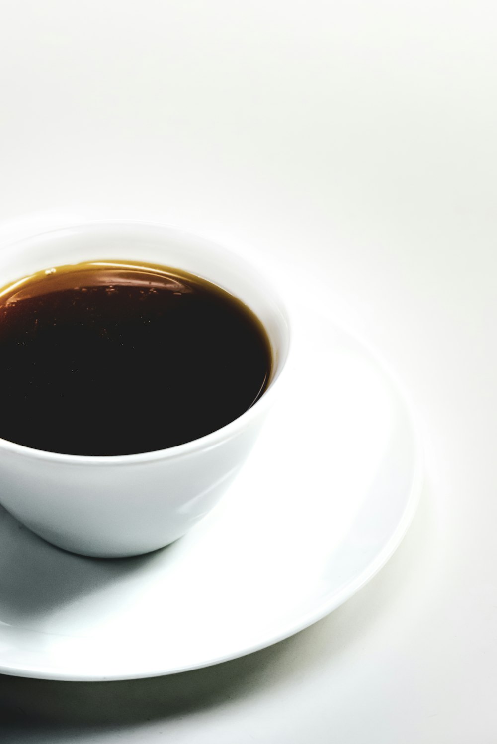 black liquid-filled cup on saucer