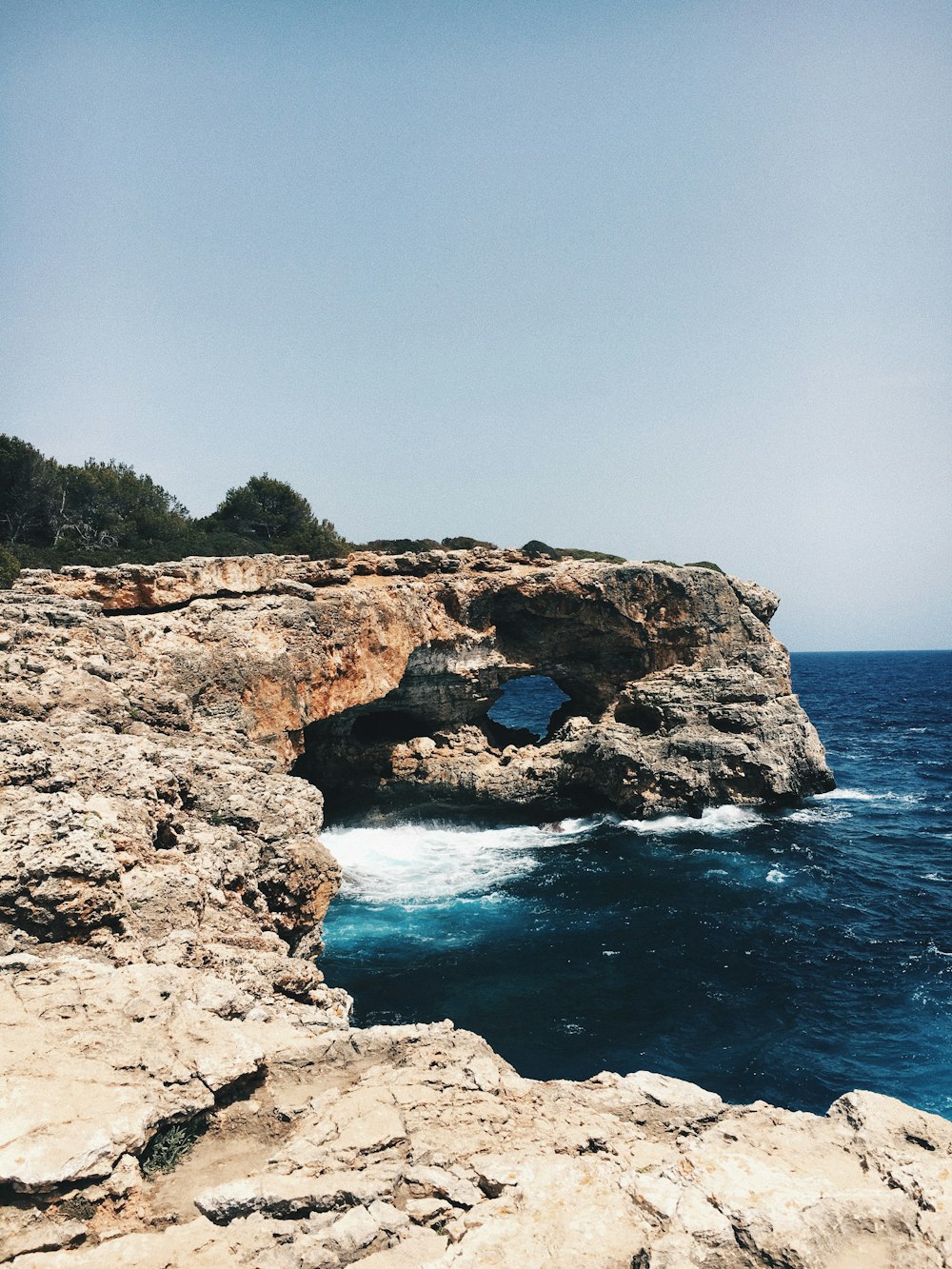 brown and black rock formation beside ocean