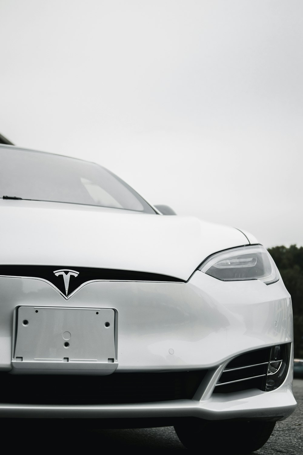 a white tesla car parked in a parking lot