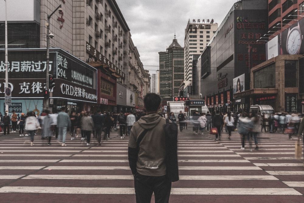 man in gray hoodie in pedestrian lane