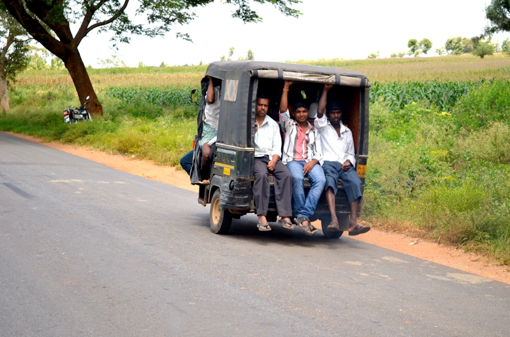 men riding auto-rickshaw