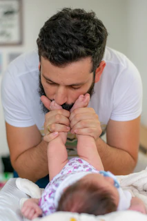 man kissing baby's feet