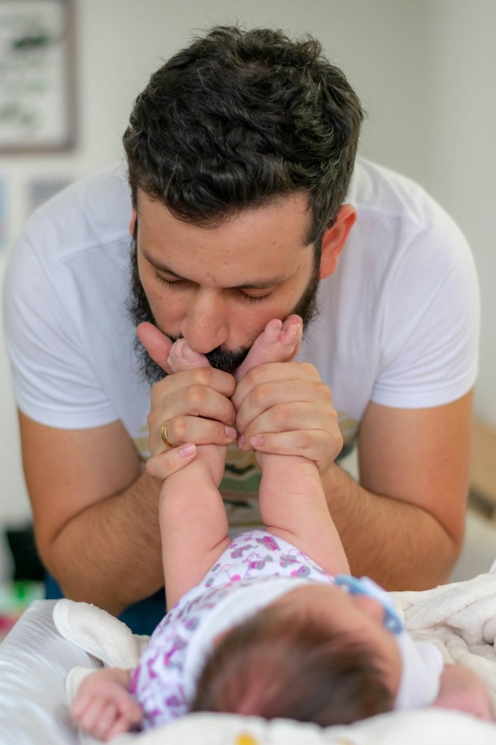 man kissing baby's feet