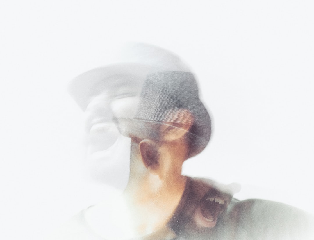 a blurry photo of a man with a hat, Catastrophic thoughts lurking inside.