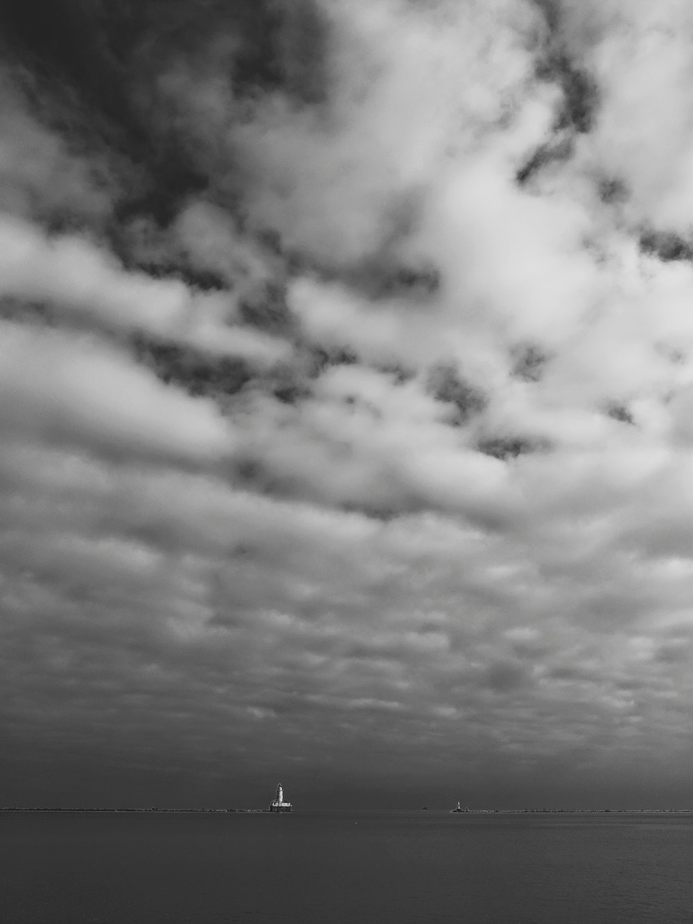 a black and white photo of a boat in the ocean