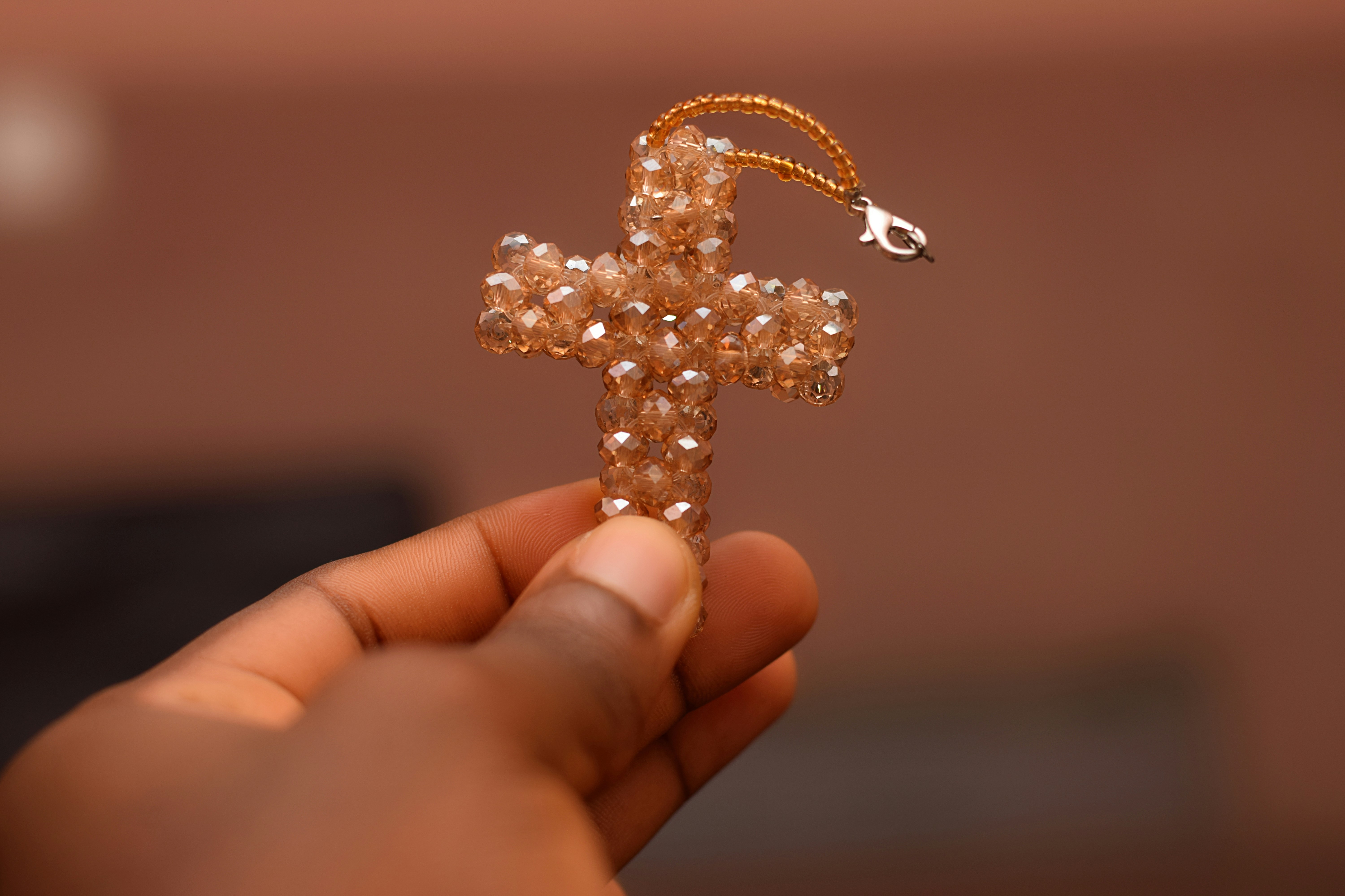 focus photography of gold-colored cross pendant