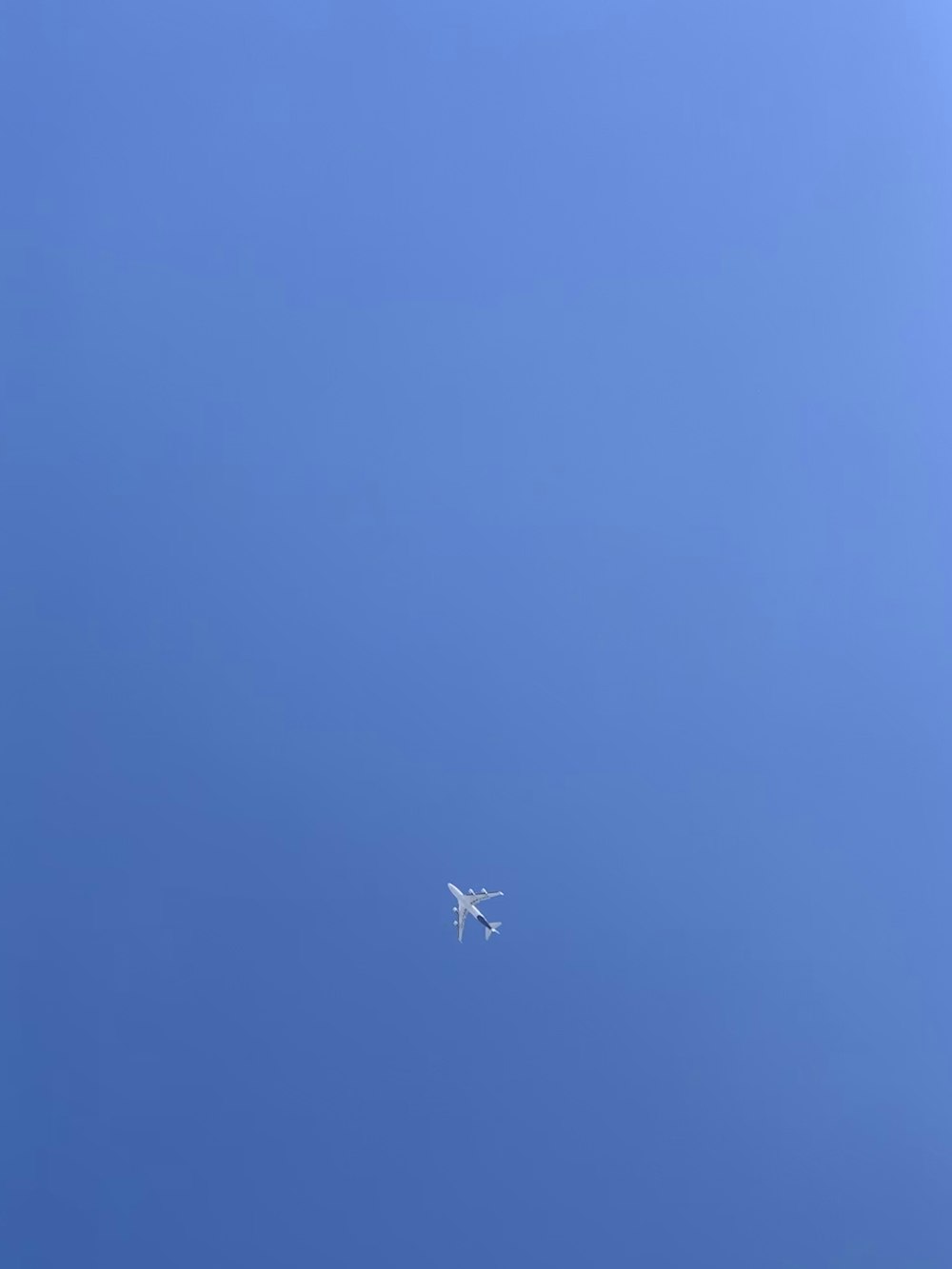 blue and white airplane across blue sky
