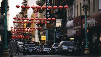 Bustling street scene in Chinatown with traditional lanterns overhead