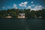 Exterior view of Hickory Lake House nestled among tall trees with the lake shimmering nearby.