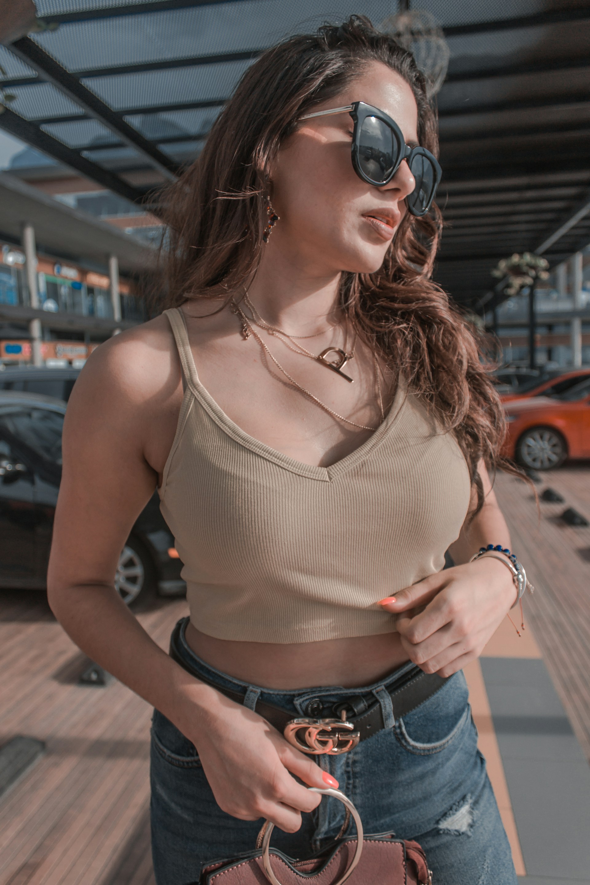 woman holding handbag standing near parked vehicles