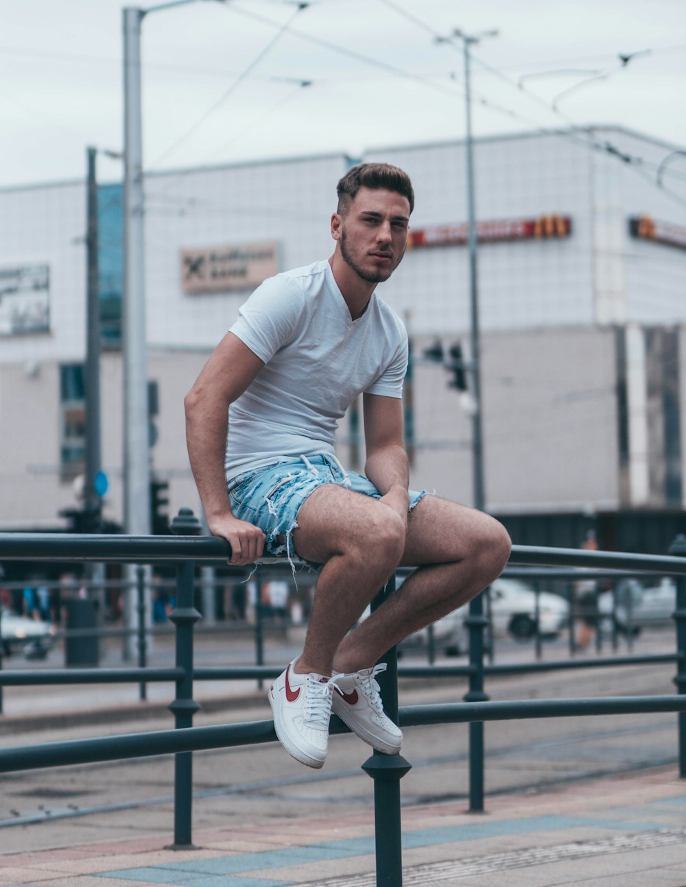 man sits on metal railings