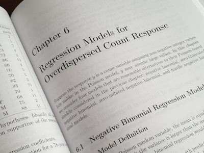 A textbook is open to Chapter 6, titled 'Regression Models for Overdispersed Count Response.' The page discusses various statistical models, including the negative binomial regression model, providing mathematical explanations and theoretical backgrounds.