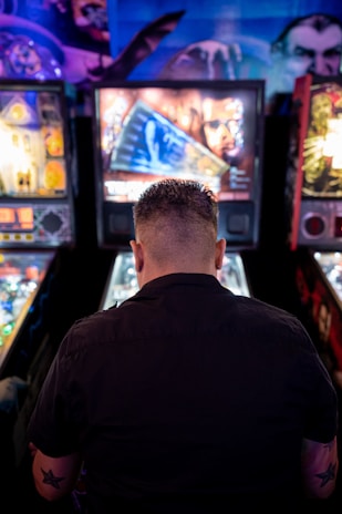 man playing arcade machine