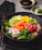 A beautifully arranged poke bowl featuring a variety of colorful ingredients including sliced cucumbers, diced orange and red fish, edamame beans, seaweed, thinly sliced onions, and brown rice. The dish is garnished with sesame seeds and accompanied by a small dish of soy sauce and a wasabi mound in the background. Chopsticks are placed adjacent to the bowl, enhancing the presentation.