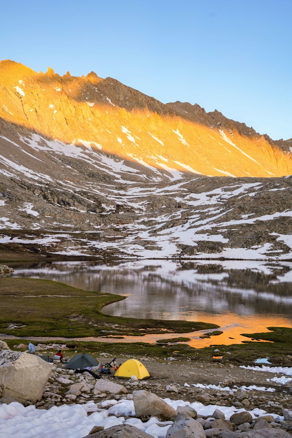 Persone accanto alla tenda vicino al lago