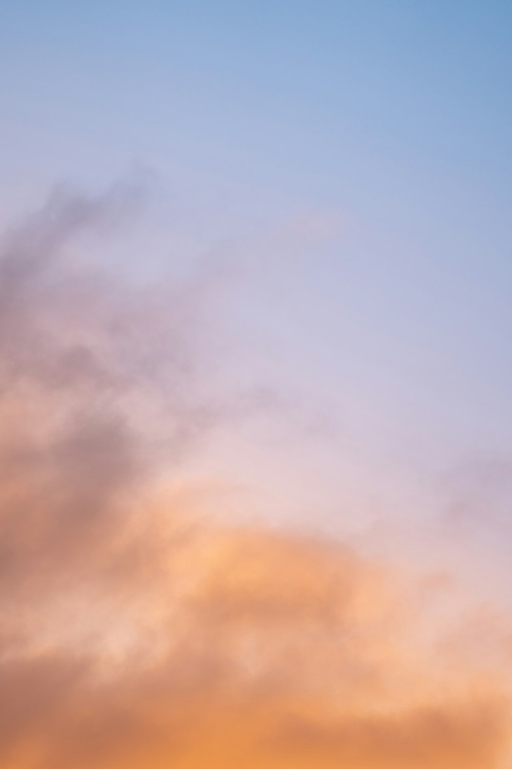 a plane flying in the sky at sunset