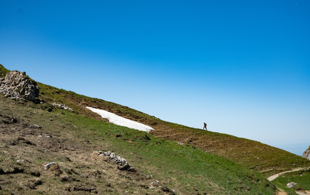 persona che cammina sulla montagna durante il giorno